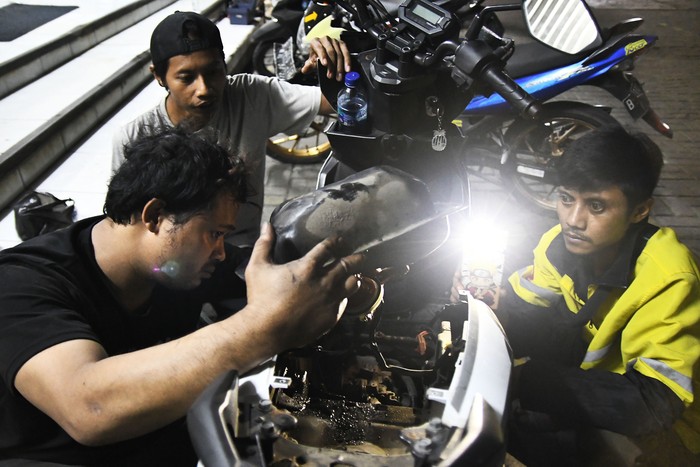 Seorang teknisi menumpahkan isi tangki bensin motor yang mogok  ke dalam dirigen usai mengisi di salah satu pom bensin di Jalan Ir Juanda, Bekasi, Jawa Barat, Selasa (26/3/2024) dini hari Menurut keterangan konsumen yang terdampak sebanyak puluhan kendaraan bermotor mogok usai isi bensin dan pihak dari pom bensin mengganti 100 persen biaya kerusakan kendaraan yang rusak. ANTARA FOTO/ Fakhri Hermansyah/foc.