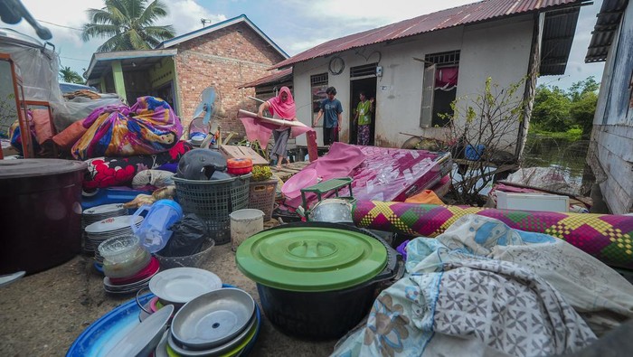 Penampakan Rumah Roboh Terseret Gulma di Muara Jambi Warga mengambil sisa-sisa kayu di samping rumahnya yang hampir roboh akibat terseret tumpukan gulma atau rumput kumpeh di Tanjung, Kumpeh, Muaro Jambi, Jambi, Senin (25/3/2024). Belasan rumah di bantaran Sungai Kumpeh tersebut roboh akibat terseret tumpukan gulma yang hanyut terbawa arus sungai itu. ANTARA FOTO/Wahdi Septiawan/YU