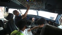 Pekerja dari Garuda Maintenance Facility (GMF) melakukan perawatan ruang kemudi pesawat Garuda Indonesia.  