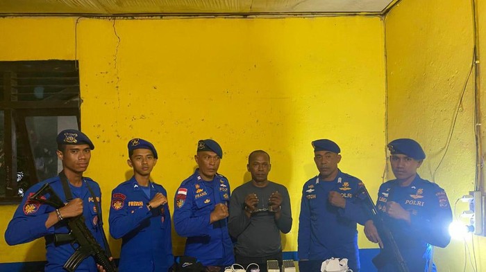 Polisi saat mengamankan pembawa 200 detonator (baju kaos hitam) di Pantai Palo, Kabupaten Flores Timur, NTT. (Dok Polairud Polda NTT).