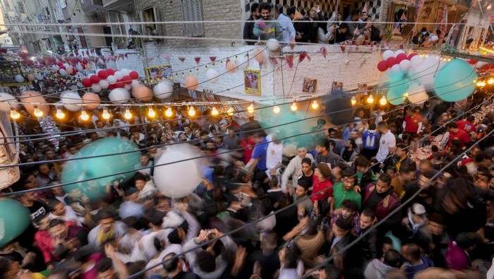 Potret Kemeriahan Ramadan di Kairo Mesir, Semua Orang Bersuka Cita Residents of Ezbet Hamada in Cairo's El Matareya district peer from their balconies to celebrate a mass breakfast,