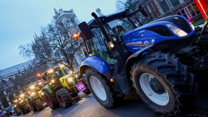 Puluhan Traktor Konvoi di Parlemen Inggris Protes Impor Pangan Farmers drive tractors through central London to protest against issues including food imports, as part of demonstrations from growers around the world, in London, Britain, March 25, 2024. REUTERS/Toby Melville