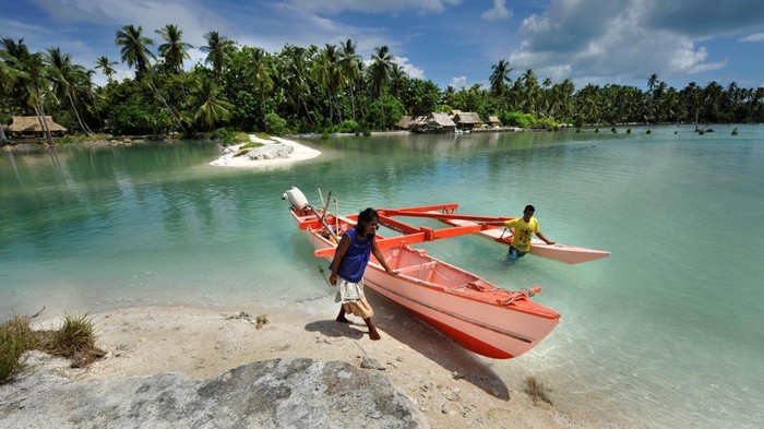 Kiribati Islands, Climate Change. The village of Tebunginako on the island of Abaiang has been relocated because of rising seas and erosion. Locals cross a former freshwater lagoon that now is flooded with sea water. (Photo by Justin Mcmanus/The AGE/Fairfax Media via Getty Images via Getty Images)