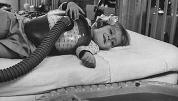 Hewan Digunakan Sebagai Bagian Terapi Medis, 1956 . Peggy Kennedy yang berusia tiga tahun menikmati bebek-bebek ini mengayuh di dalam bak mandi. Peggy, Penderita Polio, Memakai Respirator Dada Plastik Foto: Boredpanda
