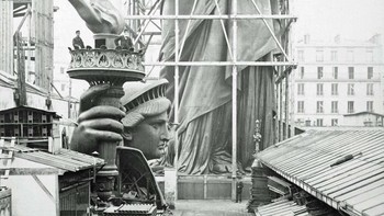 Foto Patung Liberty sedang dirakit di Paris, 1883. Kepalanya diletakkan di tanah sedangkan bagian bawahnya dirangkai dalam perancah. Foto: HistoryDefined