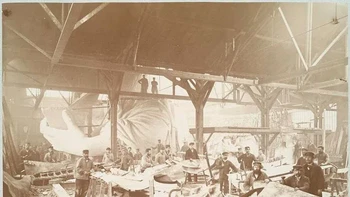 Para pekerja membuat lembaran tembaga dengan latar belakang lengan Patung Liberty. Foto: HistoryDefined