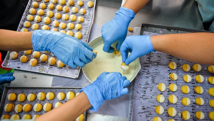 Pekerja menyelesaikan produksi kue kering di pabrik kue J&C Cookies, Cimenyan, Kabupaten Bandung, Jawa Barat, Rabu (27/3/2024). Pada Bulan Suci Ramadhan 1445 H, J&C cookies menargetkan dapat memproduksi sebanyak 500 hingga 600 lusin kue kering atau atau 10.000 toples per hari guna memenuhi kebutuhan pelanggan dan reseller yang berada di berbagai kota di Indonesia. ANTARA FOTO/Raisan Al Farisi/Spt.