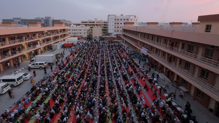 Muslims pray at charity Iftar camp, with workers housings visible in the background, during the Muslim holy month of Ramadan in Dubai, United Arab Emirates, March 26, 2024. REUTERS/Amr Alfiky
