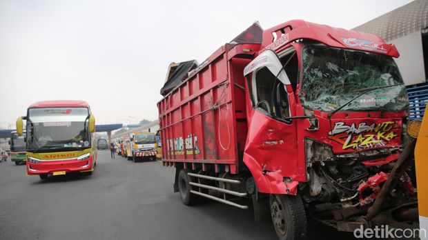 Petugas mengevakuasi kendaraan yang terlibat kecelakaan di Gerbang Tol Halim Utama, Jakarta Timur, Rabu (27/3/2024).