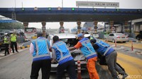 Petugas mengevakuasi kendaraan yang terlibat kecelakaan di Gerbang Tol Halim Utama, Jakarta Timur, Rabu (27/3/2024). 