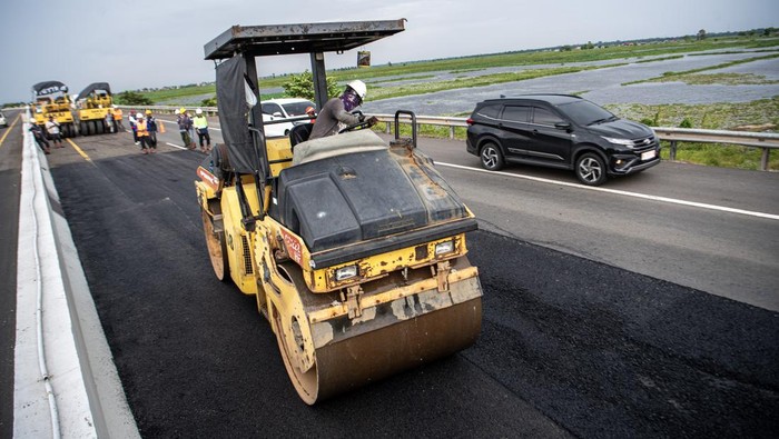 Pekerja dibantu alat berat menyelesaikan pengaspalan  Jalan Tol Trans Sumatera ruas Kayu Agung-Palembang (Kapal) di Jejawi, Ogan Komering Ilir (OKI), Sumatera Selatan, Senin (27/3/2023). Untuk memperlancar arus mudik 2024 serta meningkatkan kenyamanan pemudik, PT Waskita Sriwijaya Tol melakukan perbaikan di Jalan Tol Trans Sumatera ruas Kayu Agung-Palembang (Kapal) dengan metode Scrapping Filling Overlay, Leveling, Patching dan ditargerkan selesai pada H-7 Idul Fitri 1445 H. ANTARA FOTO/Nova Wahyudi/foc.