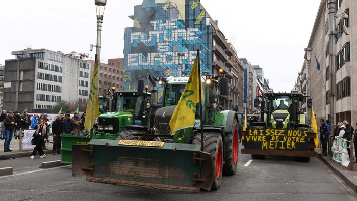 Smoke rises next to tractors as Belgian farmers take part in a protest over price pressures, taxes and green regulation, on the day of an EU agriculture ministers' meeting in Brussels, Belgium March 26, 2024. REUTERS/Yves Herman