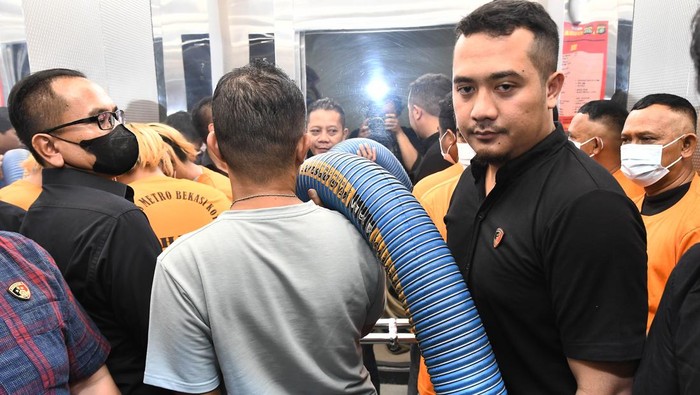 Seorang petugas Kepolisian membawa barang bukti selang untuk mencampur bensin dengan air usai rilis di Mapolres Bekasi Kota, Jawa Barat, Rabu (27/3/2024). Kepolisian mengamankan tiga tersangka bernama AD, EK, SH  yang bertugas sebagai supir serta kenek truk tangki atas kasus bensin yang dicampur air di pom bensin dengan kerugian mencapai Rp14 juta dari hasil penjualan bensin 1800 liter dan dua orang saksi masih dalam penyelidikan. ANTARAFOTO/ Fakhri Hermansyah/nz