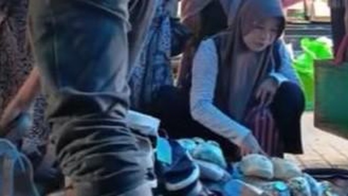 Tangkapan layar korban saat memilih sandal dan dompetnya dicuri oleh emak-emak di Pasar Mare, Bone, Sulsel.