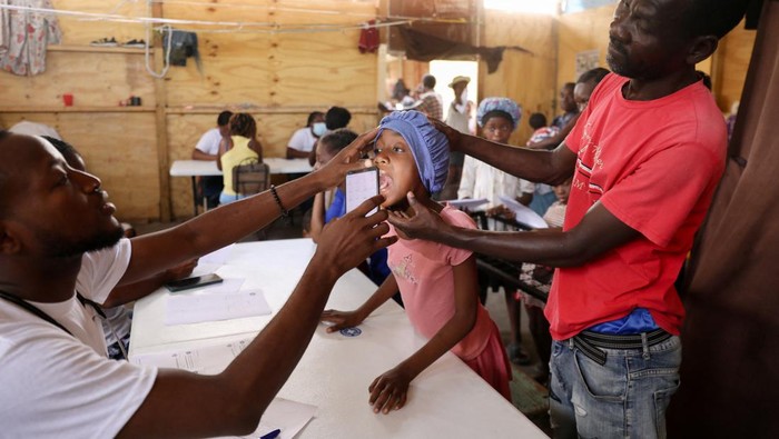 People wait to be treated by health workers at a mobile health clinic organized by UNICEF and Medecins du Monde for people displaced by gang violence, in Port-au-Prince, Haiti March 26, 2024. REUTERS/Ralph Tedy Erol