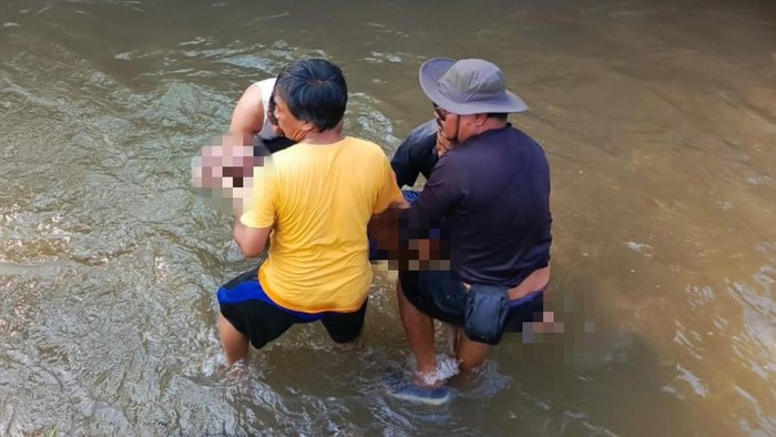 Warga mengevakuasi jasad kakek 82 tahun yang hanyut di Sungai Ayung, Banjar Semate, Abianbase, Badung, Bali, Rabu (27/3/2024). (Foto: Agus Eka/detikBali)