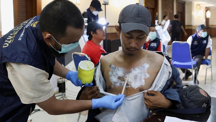 Indy, 39, reacts as she gets her tattoo removed with a laser during the event held by BAZNAS which provides a free tattoo removal program during the holy month of Ramadan at the Central Jakarta Mayor Office in Jakarta, Indonesia, March 26, 2024. REUTERS/Ajeng Dinar Ulfiana