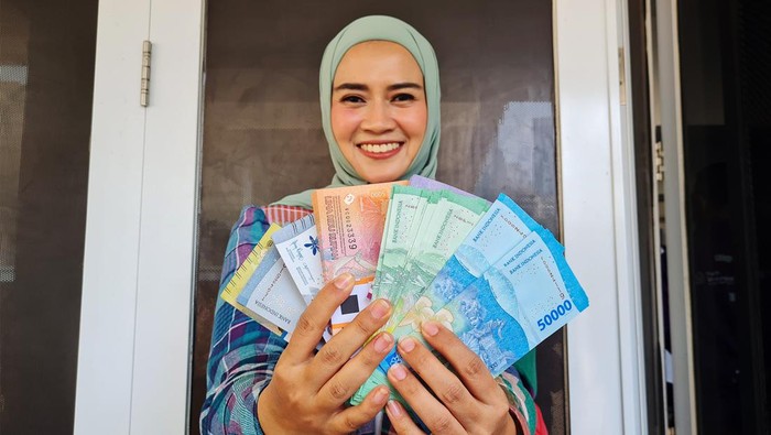 Direktur Utama PT Bank Muamalat Indonesia Tbk Indra Falatehan (kiri) dan Sekretaris Perusahaan Bank Muamalat Hayunaji (kanan) berfoto bersama masyarakat yang menukarkan uang rupiah di gerai Bank Muamalat di Istora Senayan, Jakarta, Kamis (28/3). Bank Muamalat menyiapkan uang tunai senilai Rp 736 miliar untuk melayani kebutuhan transaksi selama Ramadan dan Idul Fitri 2024.