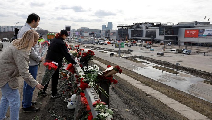 Bunga dan Boneka Penuhi Lokasi Serangan Maut Gedung Konser Moskow People lay flowers on the roadside in front of the burnt-out Crocus City Hall following a deadly attack on the concert venue on the outskirts of Moscow, Russia, March 26, 2024. REUTERS/Evgenia Novozhenina
