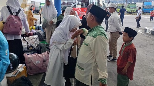 Sejumlah santri disambut keluarga saat tiba di Terminal Mengwi, Kabupaten Badung, Bali, Kamis (28/3/2024). (Agus Eka/detikBali)