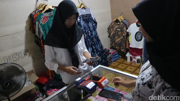 Umbarwati pedagang (kiri) pakaian dan agen bank di Pasar Juwana, Pati, Kamis (28/3/2024).