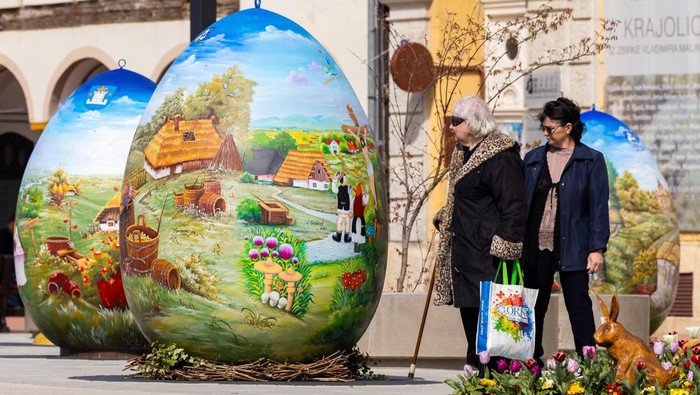 A man walks next to structures depicting Easter eggs painted in the traditional naive art style in Koprivnica, Croatia, March 27, 2024. REUTERS/Antonio Bronic