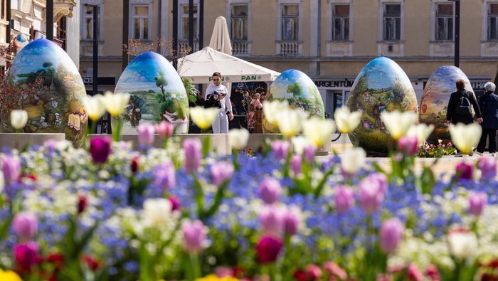 A man walks next to structures depicting Easter eggs painted in the traditional naive art style in Koprivnica, Croatia, March 27, 2024. REUTERS/Antonio Bronic