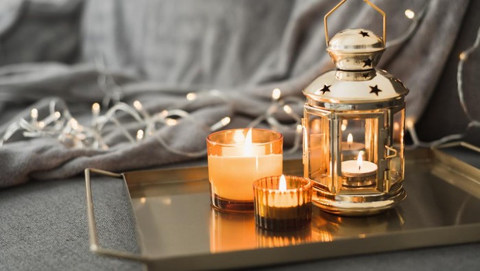 Metal lantern and burning candles on a golden metal tray. Eid al Adha celebration. Muslim holiday atmosphere