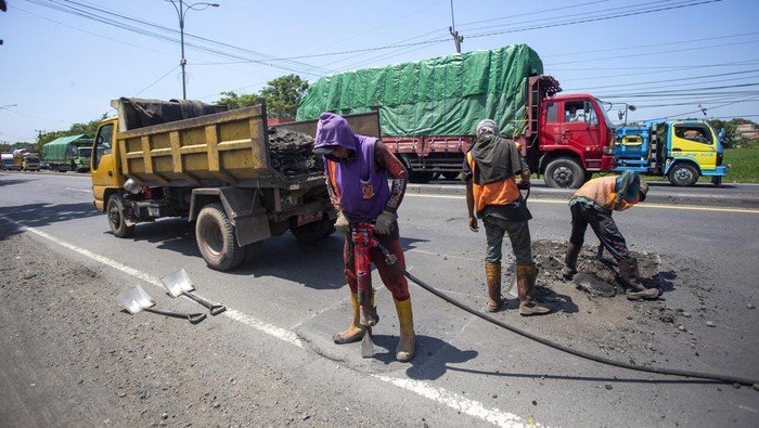 Pekerja melakukan penambalan jalan di jalur pantura Susukan, Cirebon, Jawa Bart, Jumat (29/3/2024). Perbaikan jalan di jalur pantura tersebut untuk kenyamanan pengendara dan mencegah kecelakaan saat arus mudik lebaran. ANTARA FOTO/Dedhez Anggara/nym.