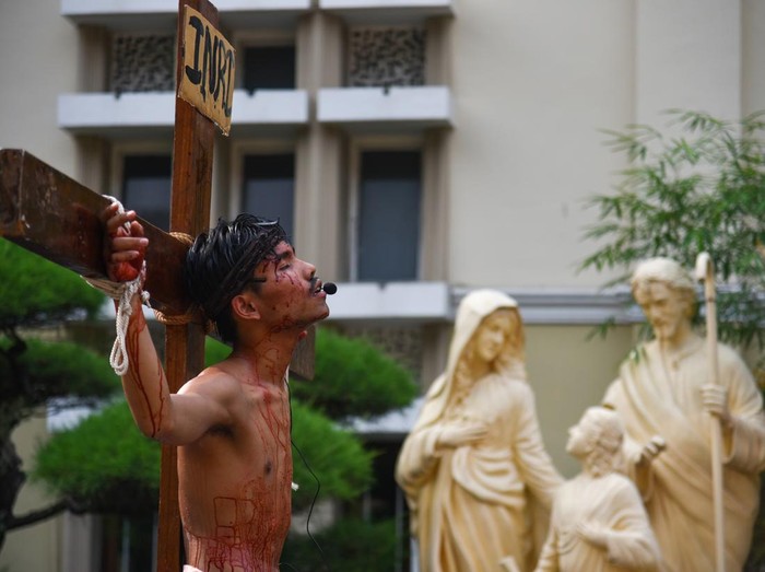Anggota Orang Muda Katolik (OMK) melakukan prosesi Tablo Kisah Sengsara Yesus Kristus pada perayaan Jumat Agung di Gereja Katedral Medan, Sumatera Utara, Jumat (29/3/2024). Prosesi tablo yang menggambarkan kesengsaraan Yesus hingga wafat di kayu salib tersebut merupakan rangkaian dari perayaan Paskah. ANTARA FOTO/Fransisco Carolio/nym.