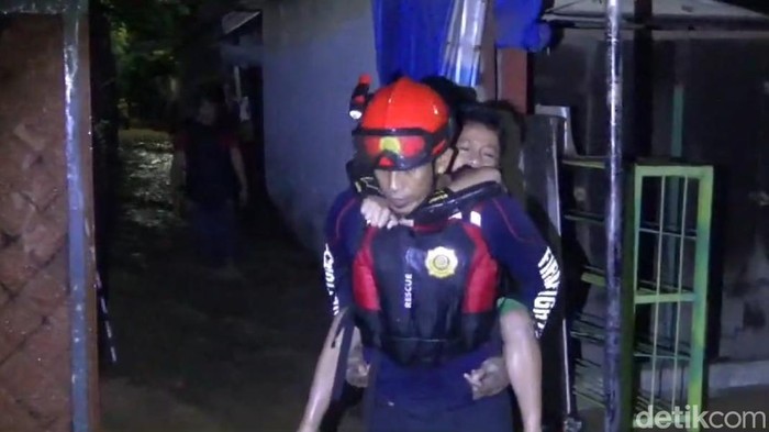 Petugas BPBD Palopo mengevakuasi korban banjir.