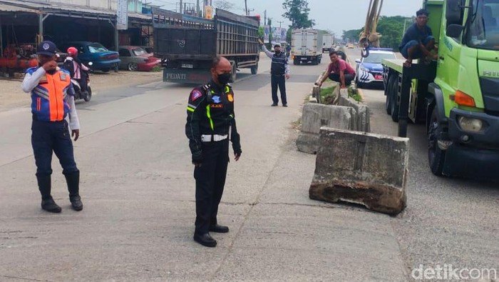 Petugas Sat Lantas Polres Karawang dan Dishub saat melakukan penutupan U-Turn di Jalan Nasional Pantura Karawang