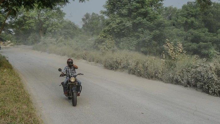 Sejumlah pengendara roda dua dan truk melintas di jalan berpasir di Jalan Lingkas Selatan, Kota Cilegon, Banten, Sabtu (30/3/2024). Jalan yang menjadi jalur utama untuk pemudik motor menuju pelabuhan Ciwandan tersebut dipenuhi pasir sehingga mengganggu kenyamanan dan kemanan pengendara terutama roda dua. ANTARA FOTO/Muhammad Bagus Khoirunas/foc.
