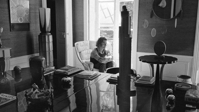 Karl Lagerfeld saat berada di apartemennya di Rue de l’Université pada awal tahun 1960-an, dikelilingi oleh pilihan perabotan dan karya seni yang eklektik.