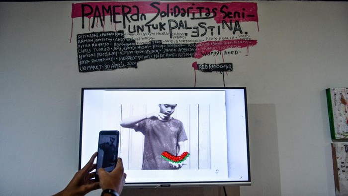Melihat Pameran Seni Solidaritas untuk Palestina di Bandung Pengunjung mengamati sebuah karya yang dipamerkan pada pameran seni solidaritas untuk Palestina di Gallery Red Raw Center, Bandung, Jawa Barat, Sabtu (30/3/2024). Pameran yang menampilkan 30 karya lukisan, foto, ilustrasi, puisi, dan rajut dari 25 orang seniman multi disiplin dari Bandung, Jakarta, Depok, Cirebon tersebut ditujukan sebagai salah satu bentuk solidaritas untuk Palestina melalui bentuk karya seni. ANTARA FOTO/Raisan Al Farisi/foc.