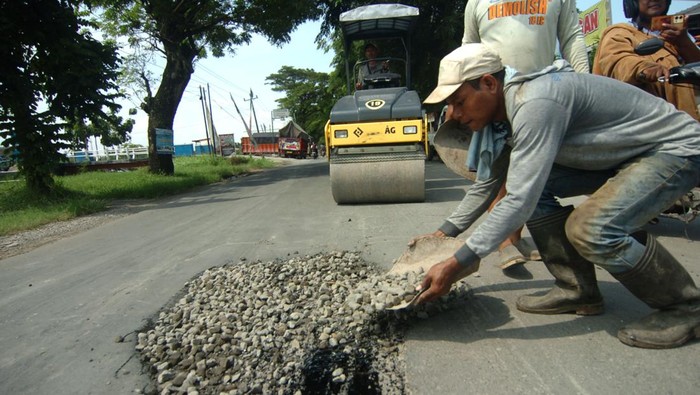 Pekerja memperbaiki jalan jalur alternatif untuk mudik Brebes-Tegal yang berlubang di Brebes, Jawa Tengah, Sabtu (30/3/2024). Perbaikan jalan rusak di sejumlah ruas jalur alternatif itu sebagai persiapan jelang arus mudik lebaran 2024. ANTARA FOTO/Oky Lukmansyah/wpa.