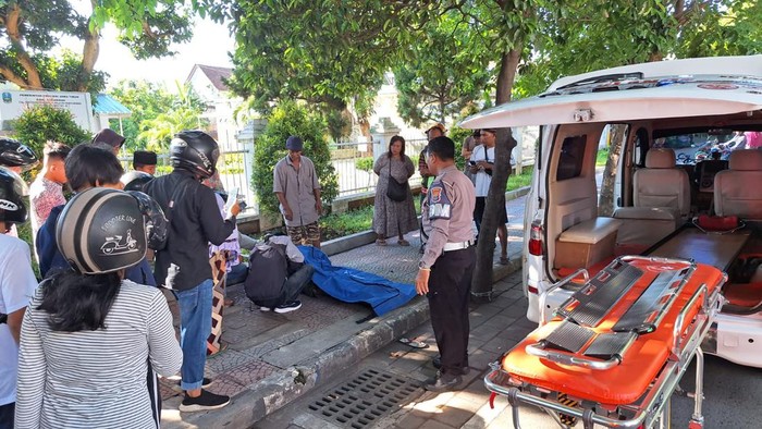 Petugas kepolisian mengevakuasi jasad Yoyok Sumaryono yang ditemukan di trotoar.