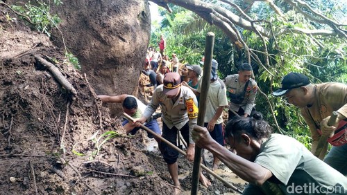 Polisi dan warga membersihkan material longsor di ruas jalan yang menghubungkan Haweo-Desa Golo Riwu di Kecamatan Kuwus Barat, Manggarai Barat, NTT.