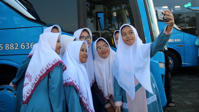 Sejumlah santri berswafoto saat mengikuti mudik bareng di parkiran makam KH Abdurrahman Wahid atau Gus Dur Tebuireng, Kabupaten Jombang, Jawa Timur, Sabtu (30/3/2024). Sebanyak 4 ribu santri Pesantren Tebuireng mudik bareng jelang perayaan Idul Fitri 1445 Hijriah. ANTARA FOTO/Syaiful Arif/wpa.