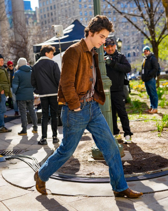 Ketika proses pengambilan gambar pada siang hari, Timothee berpakaian kemeja kotak-kotak, dipadu jeans agak longgar. Gayanya dilengkapi jaket suede coklat dan boots senada. (Foto: MEGA/GC Images)
