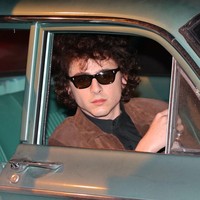 Kacamata hitam wayfarer yang klasik ikut melengkapi gayanya sebagai Bob Dylan. Hair do juga dikondisikan seperti Bob Dylan yang identik dengan rambut ikalnya. (Foto: Jose Perez/Bauer-Griffin/GC Images)