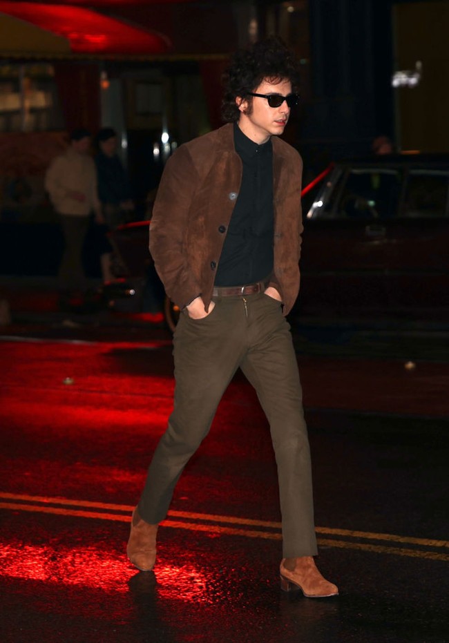 Masuk malam hari, ia tampil dengan kemeja polos gelap yang dipasangkan dengan celana coklat berpotongan langsing. Jaket dan sepatu senada juga jadi andalan. (Foto: Jose Perez/Bauer-Griffin/GC Images)