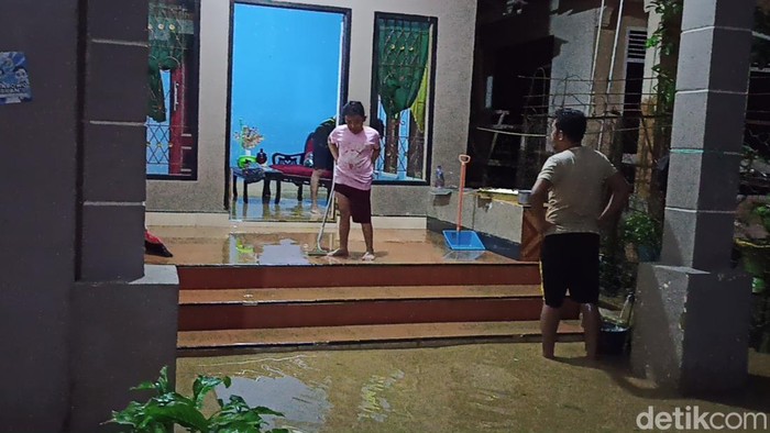Warga Palopo saat membersihkan rumahnya dari material lumpur usai banjir bandang.