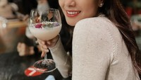 Cantiknya gaya Nisya saat nongkrong di salah satu kafe, ditemani segelooas mocktail dengan edible flower. Foto: Instagram @nissyaa