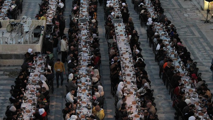 Muslims gather to eat Iftar, the first meal after breaking the fast, organized by local charitable organizations and Syria Trust for Development at the Umayyad mosque in Aleppo, Syria March 30, 2024. REUTERS/Firas Makdesi