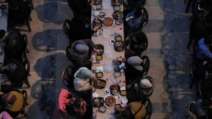 Muslims gather to eat Iftar, the first meal after breaking the fast, organized by local charitable organizations and Syria Trust for Development at the Umayyad mosque in Aleppo, Syria March 30, 2024. REUTERS/Firas Makdesi