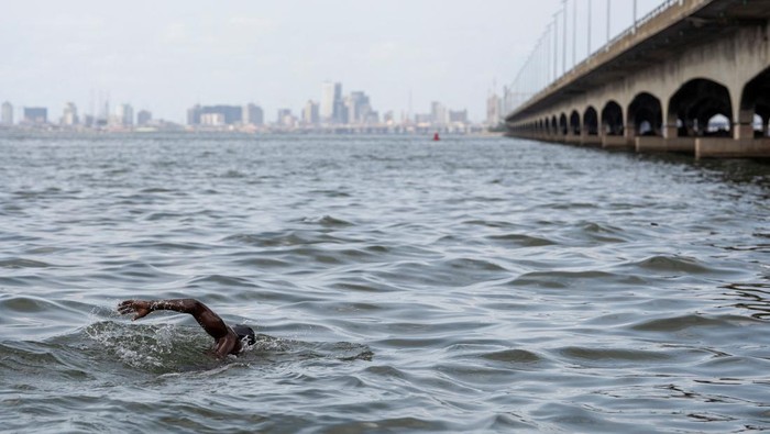 Akinrodoye Samuel jumps into the water, to start his ambitious endeavor to swim the 11.8 km stretch of the Third Mainland Bridge, advocating for the theme 'Swim Against Suicide And Depression' in Lagos, Nigeria, March 30, 2024. REUTERS/Marvellous Durowaiye