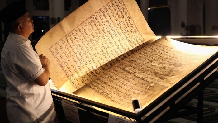 Al Quran kuno di Masjid Nasional Al Akbar Surabaya Humas Masjid Nasional Al Akbar Surabaya H Helmy M Noor menunjukkan Al Quran kuno yang dipamerkan di Masjid Nasional Al Akbar Surabaya, Jawa Timur, Minggu (31/3/2024). Al Quran kuno tersebut memiliki berat 25 kilogram dengan panjang 110 centimeter dan lebar 180 centimeter (dalam kondisi terbuka) dan ditulis dengan tangan. ANTARA FOTO/Didik Suhartono/YU