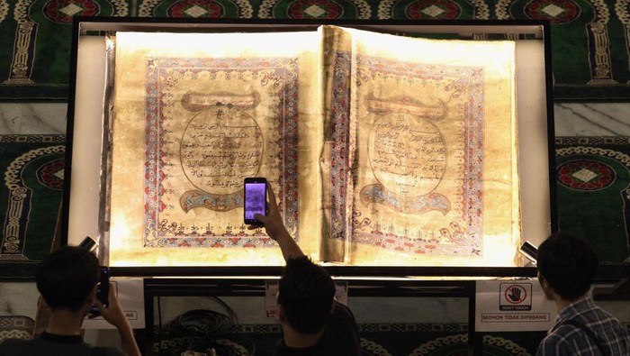 Humas Masjid Nasional Al Akbar Surabaya H Helmy M Noor menunjukkan Al Quran kuno yang dipamerkan di Masjid Nasional Al Akbar Surabaya, Jawa Timur, Minggu (31/3/2024). Al Quran kuno tersebut memiliki berat 25 kilogram dengan panjang 110 centimeter dan lebar 180 centimeter (dalam kondisi terbuka) dan ditulis dengan tangan. ANTARA FOTO/Didik Suhartono/YU