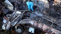 Ahli patologi forensik menyisir sisa-sisa bus yang terbakar di dekat Mamatlakala di provinsi utara Limpopo, Afrika Selatan, 29 Maret 2024.